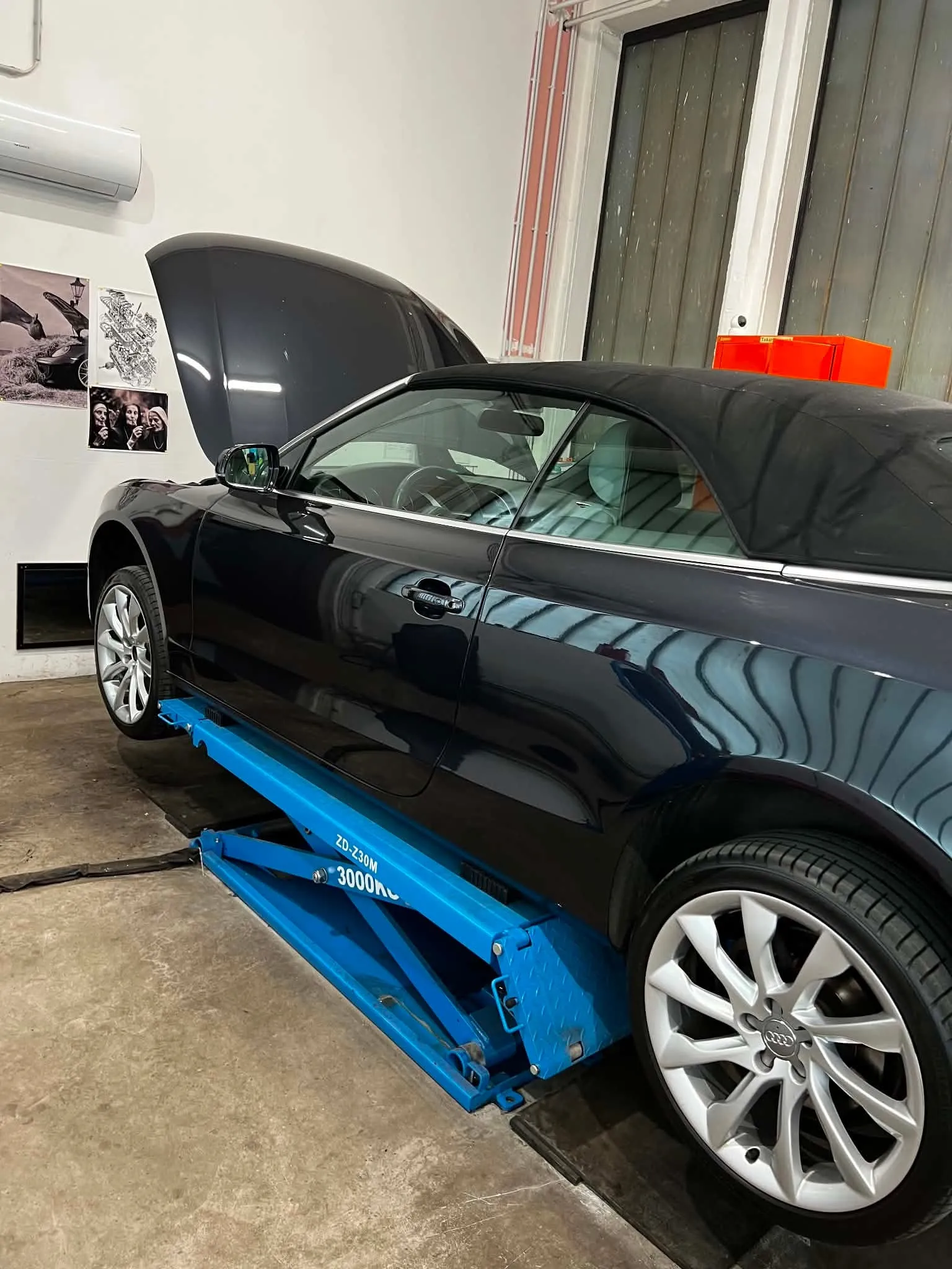 Fekete Audi A5 cabrio az ollós emelőn, futómű-átvizsgálás alatt