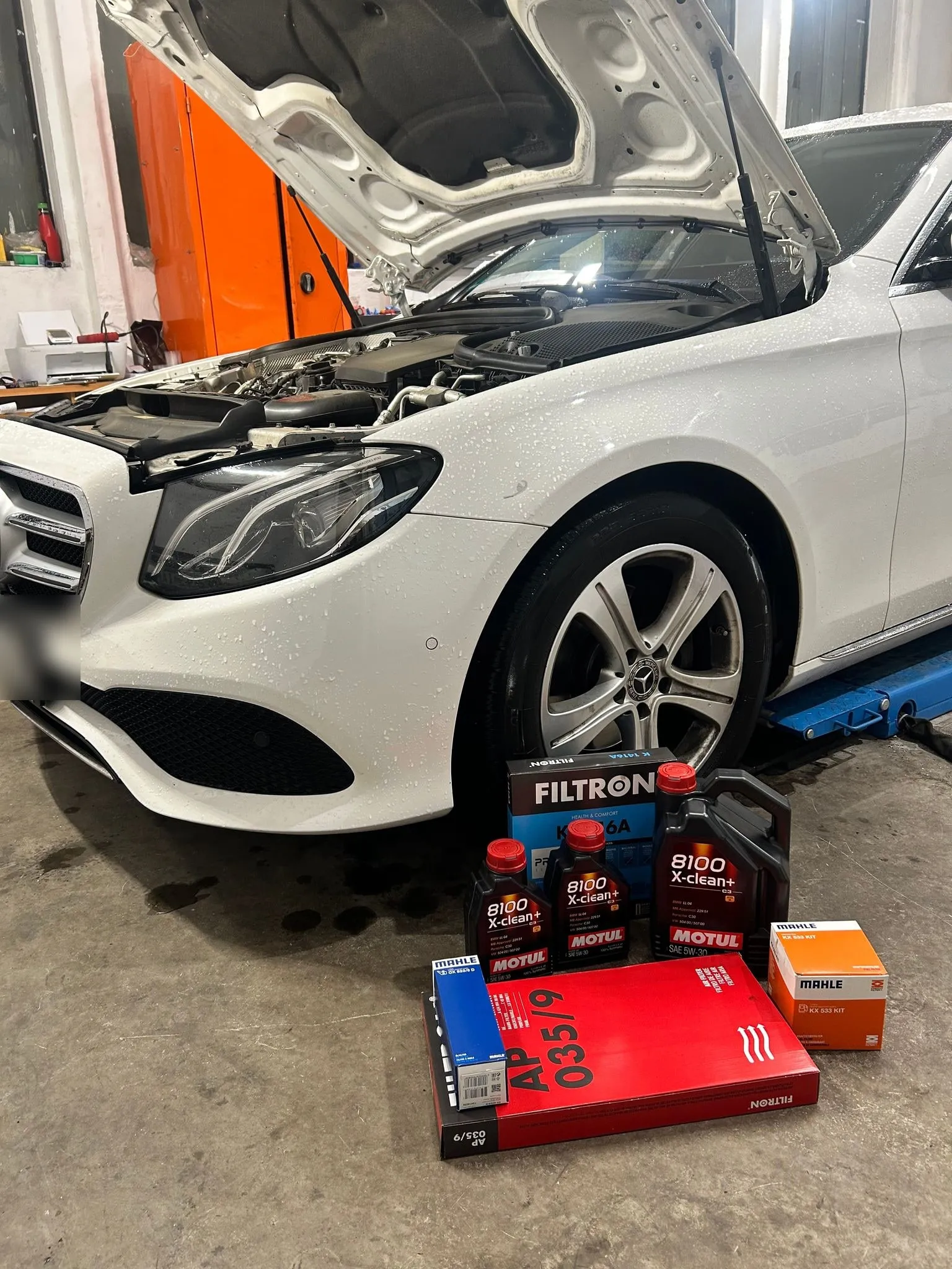 Fehér Mercedes olajcseréhez előkészített Motul olajokkal és szűrőkkel